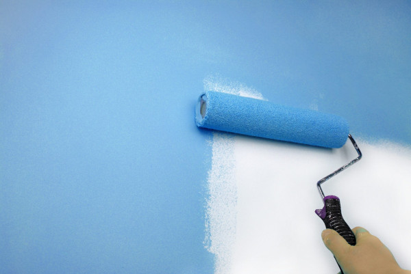 Closeup of the hand painting wall in blue
